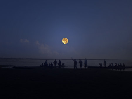 Happy people on lakeside with full moonの写真素材
