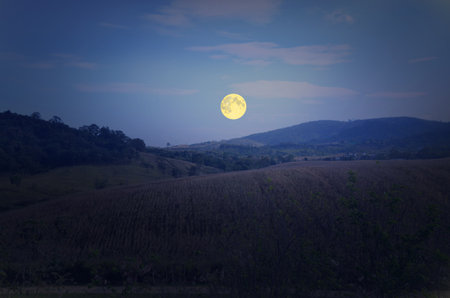 Beautiful full moon over the mountain in winterの写真素材
