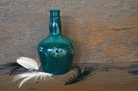 Broken green bottle on wood board backgroundの写真素材