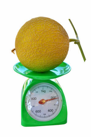 Melon weighing on green scaleの写真素材