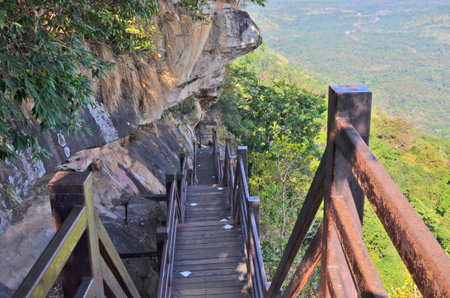 Down stairs with iron racks beside the cliffの写真素材