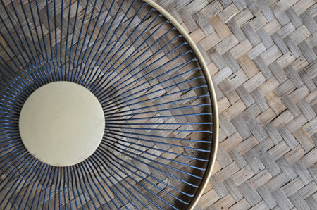 Old fan grill on woven bambooの写真素材