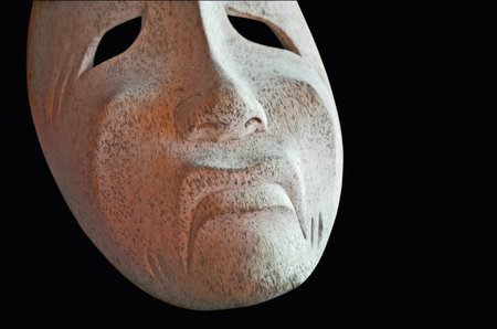 White sad mask on black backgroundの写真素材