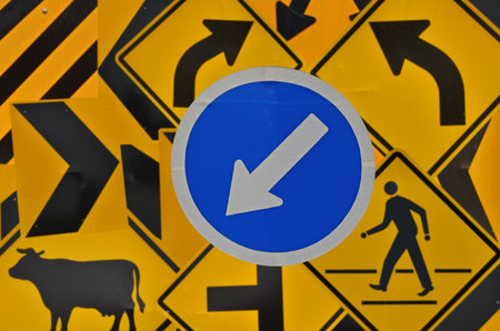 Blue warning arrow label on yellow street signの写真素材