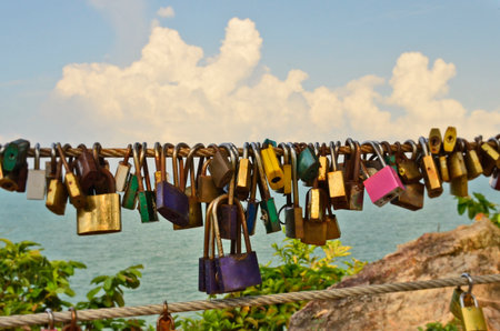 Love locks of couples on sling racks beside the sea