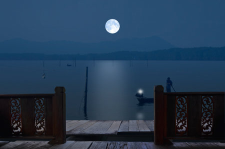 Pathway and balcony beside the lake in full moon nightの写真素材