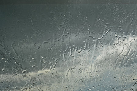 Raining water on car glass with cloudy sky backgroundの写真素材