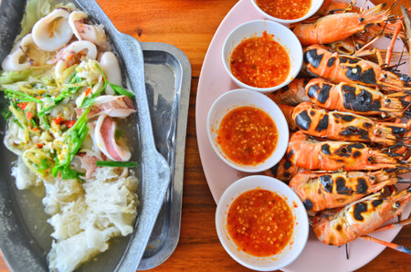 Grilled prawns and hot sour squid soup dishesの写真素材