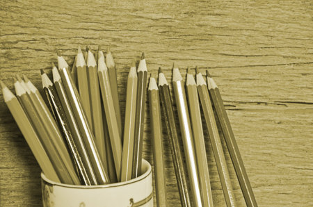Pot of drawing pencils on wood background