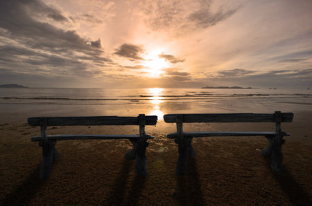 Couple seats on beautiful morning beachの写真素材