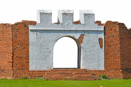 Old red brick wall with blank door and green meadowの写真素材