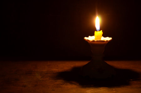 Light of yellow candle on the pedestal in the nightの写真素材