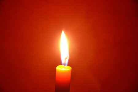Wax candle light with red clothdrop in the night