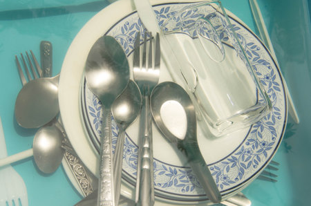 Spoons and forks with dishes soak in water