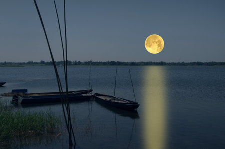 Beautiful full moon over the lake in the eveningの写真素材
