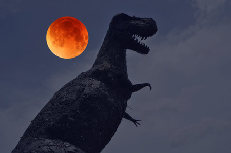 Big black dinosour manikin with red moonの写真素材