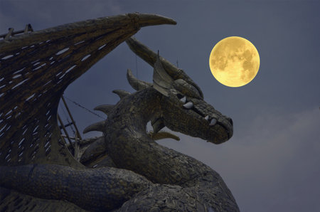 Big gold iron dragon with big moon in the nightの写真素材