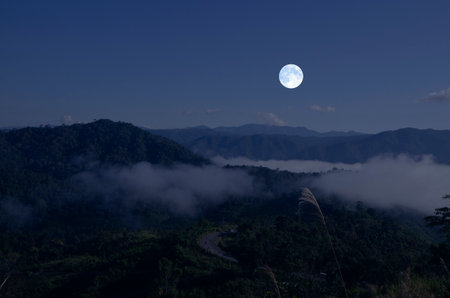Beautiful white full moon over the mountains in the winterの写真素材