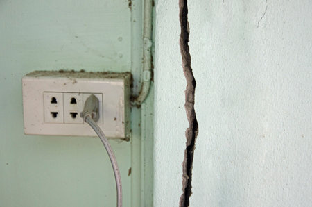 Fracture on the pole with plug hub on the wall of old concrete house