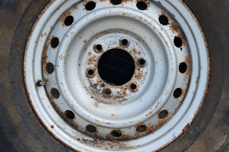 Old silver wheel rim with bolt hole, center cap and car tire close upの写真素材