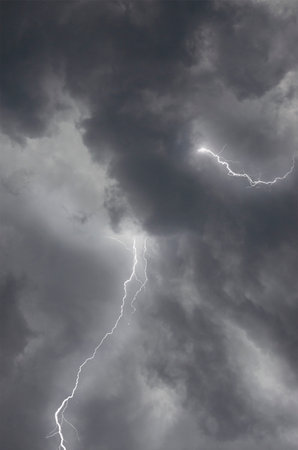 Dangerous strong lightning and hard thunder in black clouds in rain sky