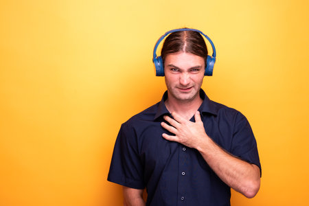Man wearing headphones resting his hand to its chestの写真素材
