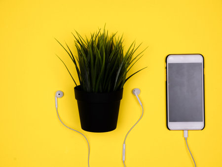 Plant pot with headphones with smartphone. Plants like music tooの写真素材