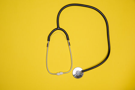 stethoscope laying against orange background flat view upside down