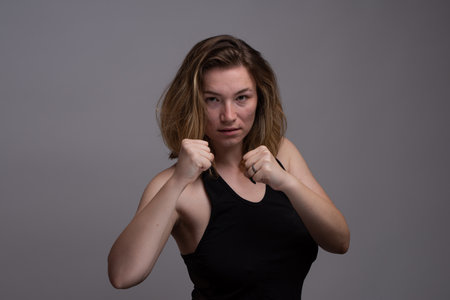 Blonde woman holding fists in aerobic punching classの写真素材