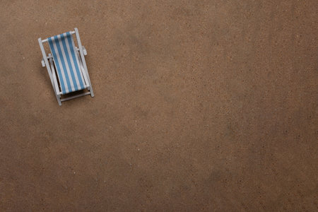 Sunbed laying on very fine dark sand in landscape flat layの写真素材