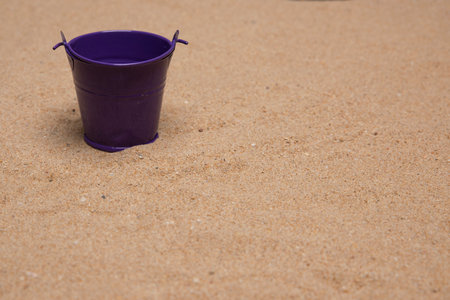 Isolated purple toy bucket on very fine sandの写真素材