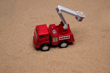 Isolated toy fire truck on very fine sand with copy spaceの写真素材