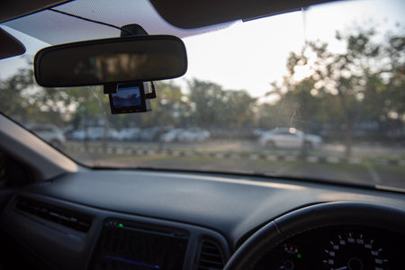 Car camera set ready for recording in front of car while a driver is ready to drive a car off the parking lot in the morning.の写真素材