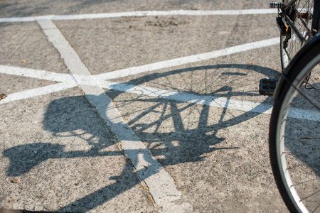 Old vintage bicycle parking near a walk way in the morning. Its shadow casts on the street with an interesting lines.の写真素材