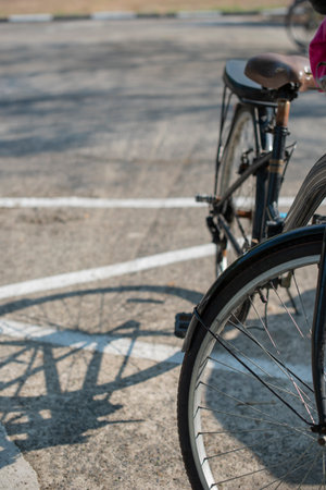 Old vintage bicycle parking near a walk way in the morning. Its shadow casts on the street with an interesting lines.の写真素材