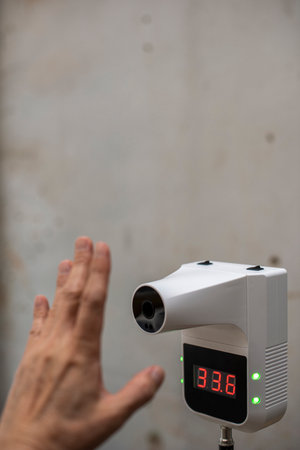 Automatic infrared thermometer, using for identify well or sick people in COVID-19 pandemic by checking temperature before entering to a shop.の写真素材