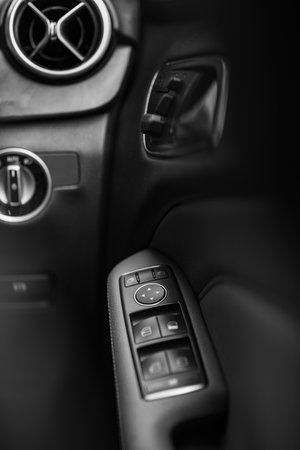 BANGKOK - Jan 22, 2022 : Inner car door handle for a driver's seat of a BENZ B180 model, showing right side door control buttons for an easy control with modern design, seeing from a back seat.のeditorial素材
