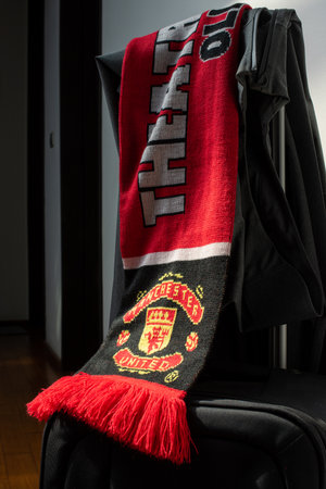 BANGKOK - January 26, 2023: Manchester United scarf placed on the luggage left in the corridor. Ready to go and cheer for a big match.のeditorial素材
