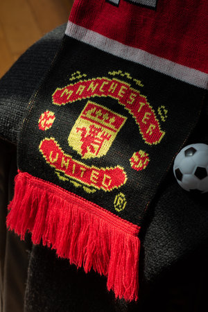 BANGKOK - January 26, 2023: Manchester United scarf placed on the luggage left in the corridor. Ready to go and cheer for a big match.のeditorial素材