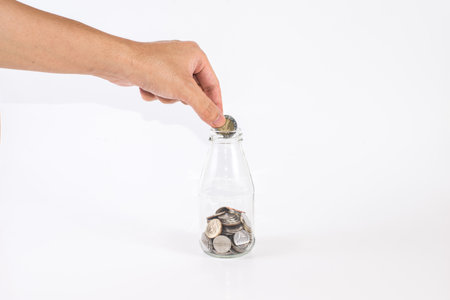 A man's hand hold coin to jarの写真素材