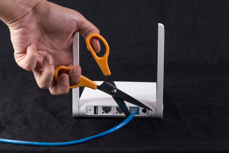 Hand cutting internet cable of router, communication conceptの写真素材