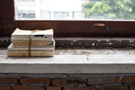 The stack of book on old plank at the windowsillの写真素材