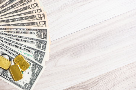 Banknote with gold bar on wooden background, business finance conceptの写真素材