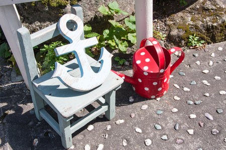 Anchor, wooden chair and watering canの写真素材