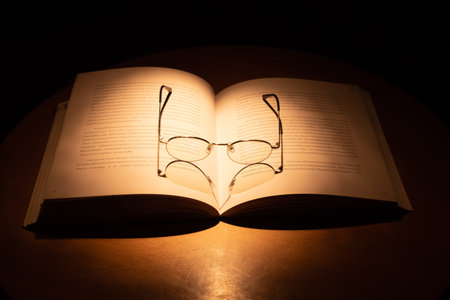 Beautiful orange yellow high contrast lighting of glasses and book in Thai letterの写真素材
