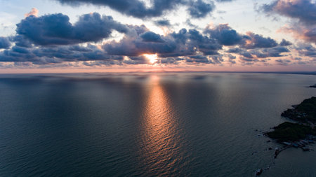 sunset in middle frame of wide ocean with mountain and cloudy weather in Chantaburi, khung kraben, Thailandの写真素材