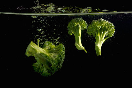 Broccoli in water on black backgroundの写真素材