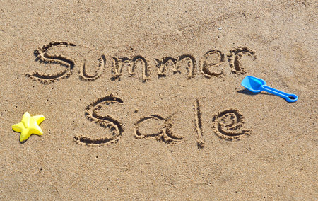 Words summer sale written in the sand at the beachの写真素材