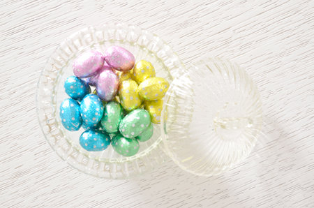 Foil wrapped chocolate Easter eggs in glass bowlの写真素材