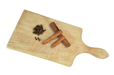Cloves and cinnamon on wooden board isolatedの写真素材